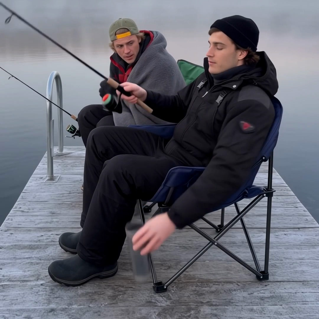 Two anglers on a frosty dock, one warm in the heated camp chair
